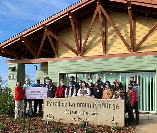 CHIP and North Valley Community Foundation staff and board members present the grant check of $649,500 in front of Paradise Community Village.