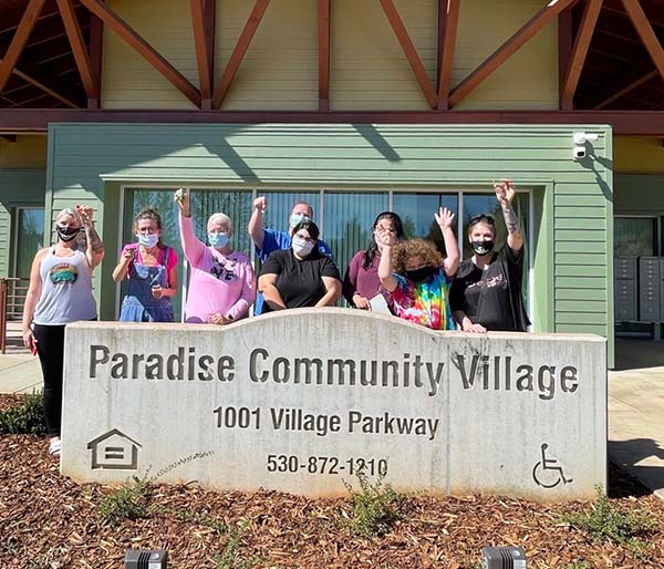 First group of residents hold up their keys to their apartments in front of Paradise Community Village