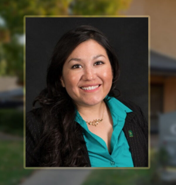 This is a graphic image with a photo of Vanessa Guerra, CHIP's Director of Rental Housing. Vaness is wearing a teal business shirt with a collar and a black jacket. Vanessa has dark hair and she is smiling. In the background is a blurry photo of the exterior of CHIP's main office which reveals some trees, a sign with CHIP's name on it, and a two-story building. I